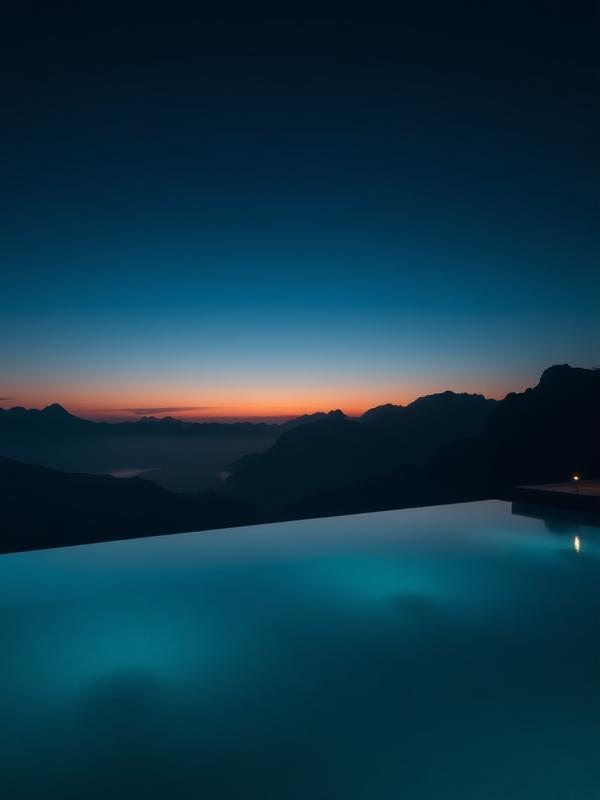Piscina infinita al anochecer con vistas a montañas